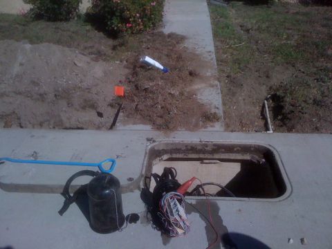 1968 Ford Mustang - A utility access box is open on a sidewalk, revealing wires and tools, with disturbed soil nearby.