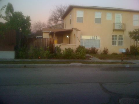 1968 Ford Mustang - A two-story residential building with a mailbox in front and a wooden fence in the yard.