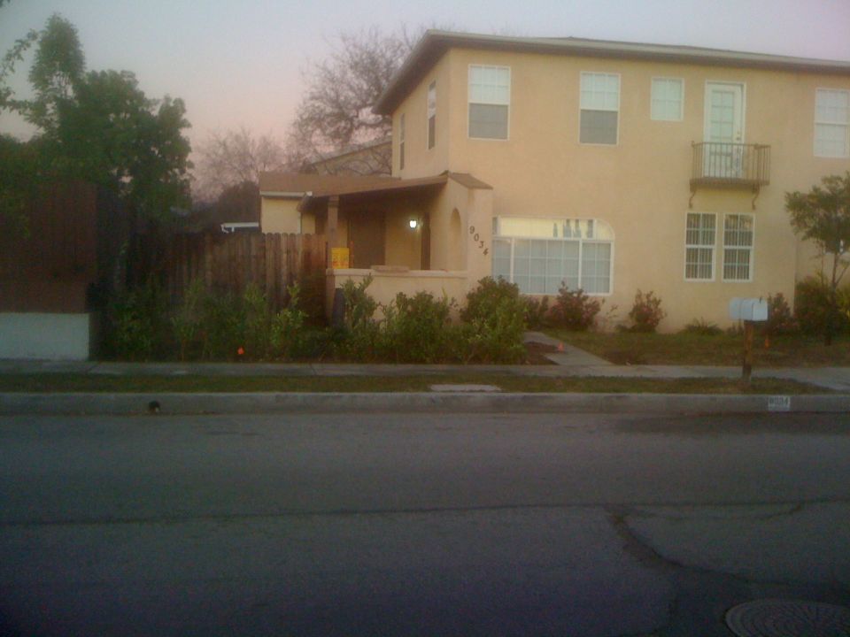 Two-story yellow house with a covered porch and a balcony