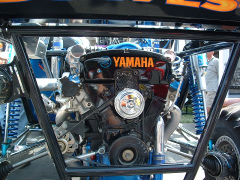 1993 Ford Taurus - Close-up of a Yamaha engine, part of a custom vehicle, with visible blue suspension.