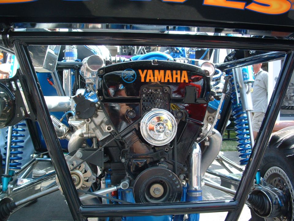 Black Yamaha engine with orange lettering, chrome accents, and blue suspension components