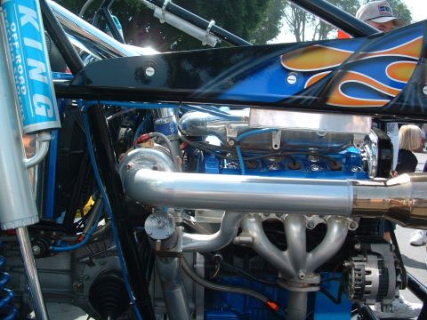 1993 Ford Taurus - Close-up view of a custom engine a turbocharger, vibrant blue block, and flame graphics on the bodywork.