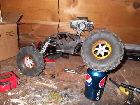 1989 Ford Bronco - A remote-controlled rock crawler sits on a workbench, its front tire balanced on a Pepsi can.