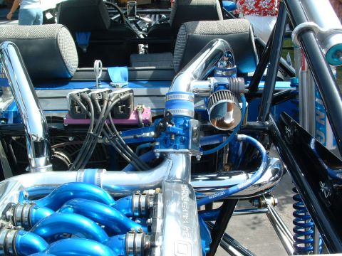 1993 Ford Taurus - Close-up of a highly modified engine bay, bright blue components and polished metal.