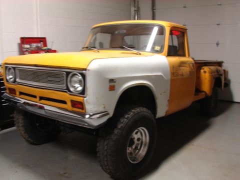 1971 International School Bus - This pickup truck, possibly a 1971 International, features a two-tone paint scheme and off-road tires.