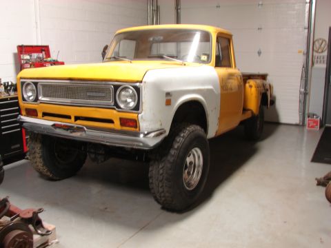 1971 International School Bus - This pickup truck, likely a 1971 model based on its grille, is shown in a garage with a two-tone paint scheme.