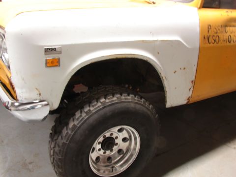 1971 International School Bus - Close-up of a 1971 International pickup truck's front fender and wheel, showing the '100' badge.