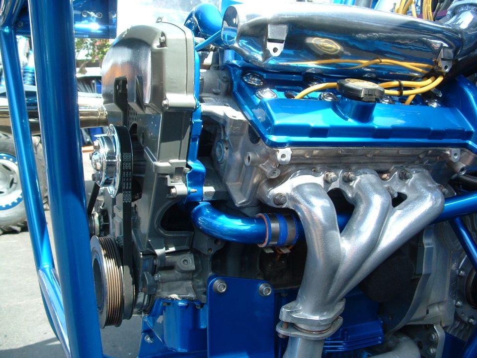 Blue engine with chrome exhaust manifold and yellow spark plug wires
