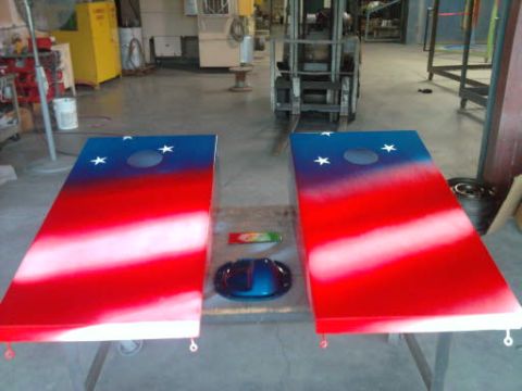 1994 Ford F-150 - Two custom-painted cornhole boards are displayed in a workshop setting, with a forklift visible in the background.