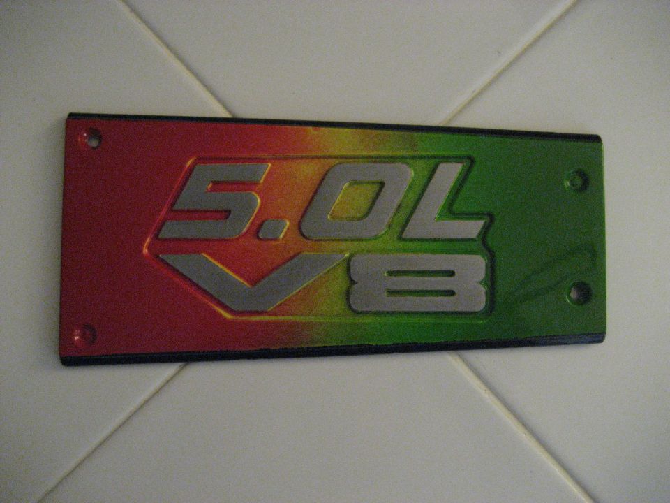 Red, yellow, and green 5.0L V8 emblem