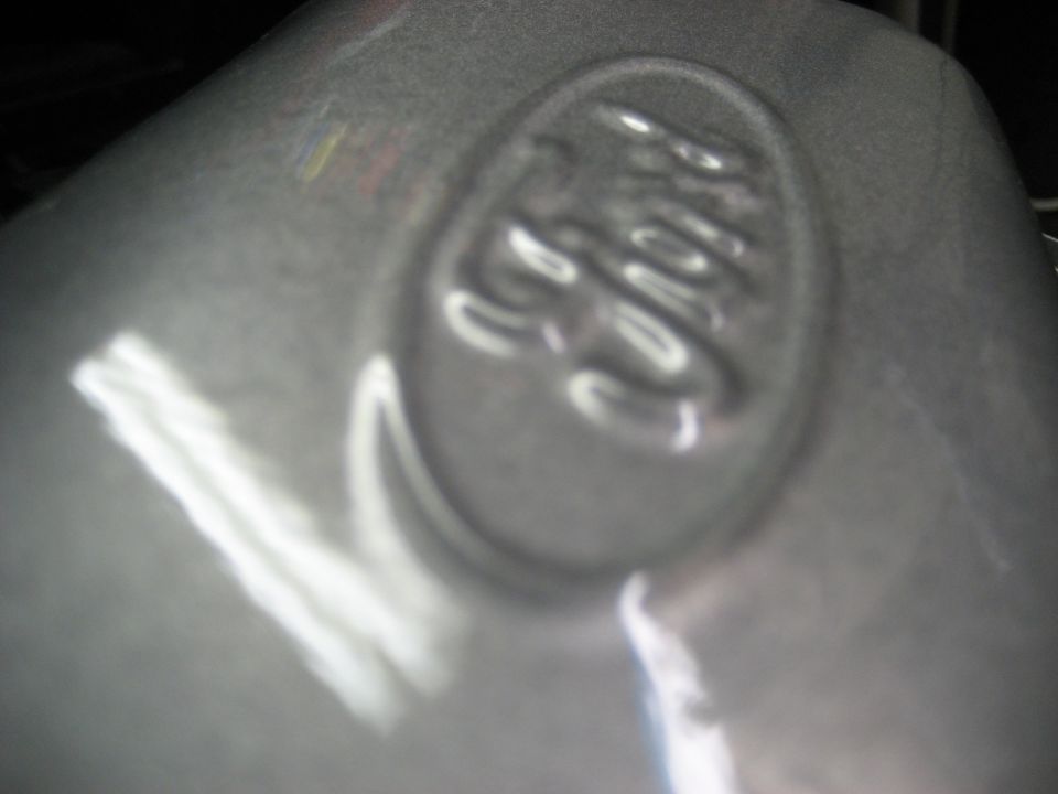 Embossed Ford emblem on a gray, metallic surface