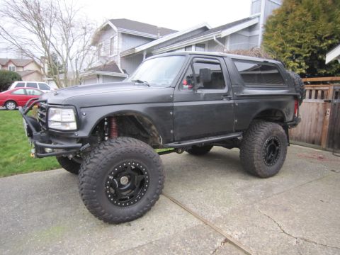 1996 Ford Bronco - This modified 1996 Ford Bronco features an aggressive stance with large off-road tires and a custom front bumper.