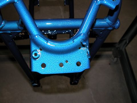 1994 Ford F-150 - A close-up view of a vehicle frame component that has been painted a metallic blue.