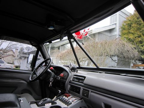 1996 Ford Bronco - The interior of a 1996 Ford Bronco shows a modified dashboard with extra switches and a decorative skull decal visible through the windshie…