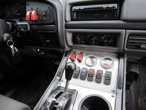 1996 Ford Bronco - Vehicle interior shows a modified center console with multiple auxiliary switches and gauges.