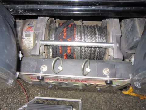 1996 Ford Bronco - A winch assembly with a steel cable and an orange strap is mounted on a vehicle, with visible text indicating "WASHINGTON POWER".