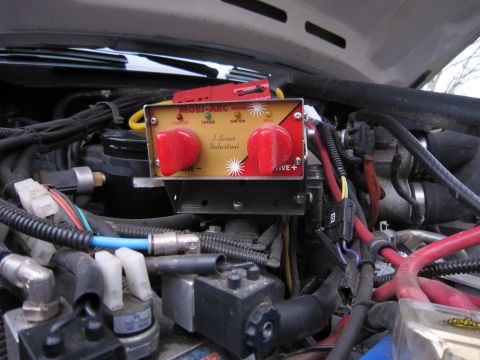 1996 Ford Bronco - Close-up of a Mobi-Arc J-Series Industrial battery charger installed in a vehicle's engine compartment.