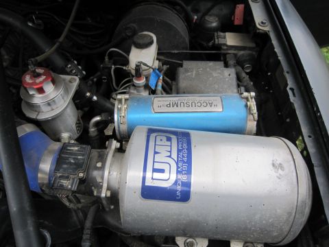 1996 Ford Bronco - Close-up view of an engine bay, showing aftermarket components like UMP and ACCUSUMP canisters.