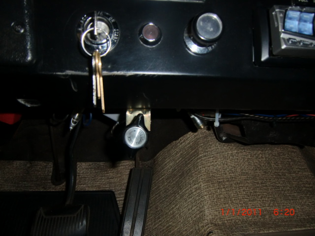 Vehicle dashboard with ignition, radio, and floor pedals visible