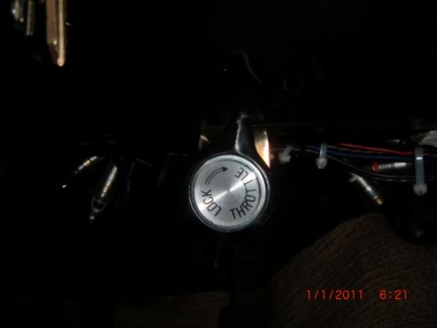 1973 Ford Bronco - Close-up of a throttle control knob, likely from a vehicle's interior, with visible text indicating 'LOCK' and 'THROTTLE' settings.