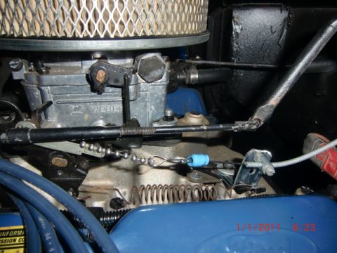 1973 Ford Bronco - Close-up view of a Weber carburetor and associated engine components, including throttle linkage and air filter.