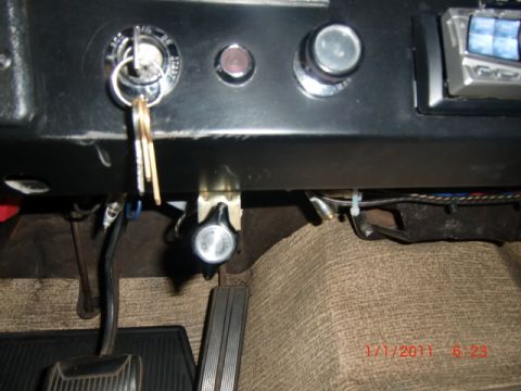 1973 Ford Bronco - Interior view of car dashboard showing keys in the ignition and floor pedals.