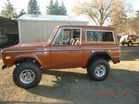 1973 Ford Bronco - This 1973 Ford Bronco features a lifted suspension and custom wheels, seen parked outdoors.