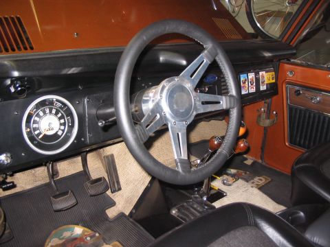 1973 Ford Bronco - The interior of the 1973 Ford Bronco features a custom steering wheel and a dashboard with classic gauges.