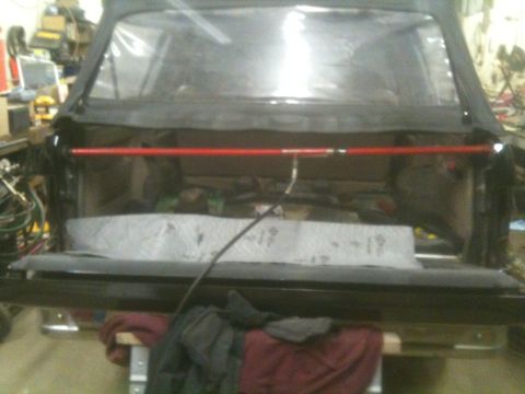 1993 Ford Bronco - Rear view of a 1993 Ford Bronco with its soft top off, revealing the interior and cargo space.