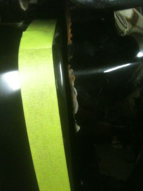 1993 Ford Bronco - Close-up of a car panel showing rust and yellow tape.