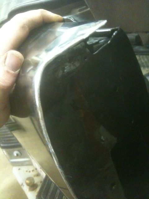 1993 Ford Bronco - Close-up of a damaged chrome trim piece, likely a car part, with a hand holding it.