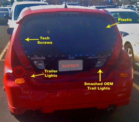 2009 Suzuki Samurai - This Suzuki Aerio features custom trailer lights and smashed OEM tail lights, with plastic and tech screws visible on the rear window.