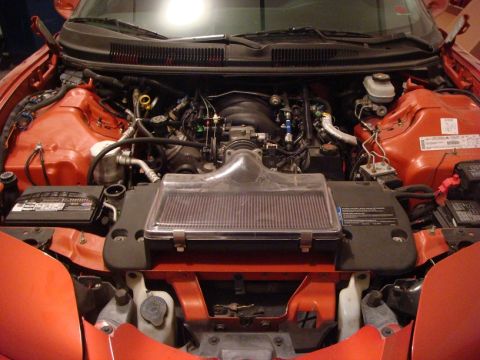 2001 Pontiac Trans Am - The engine bay of a red 2001 Pontiac Trans Am shows its V8 engine, air intake system, and battery.