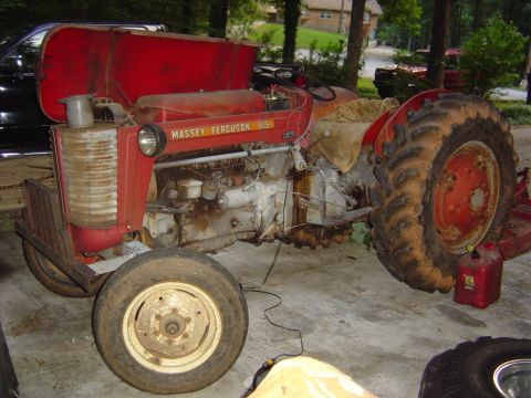 1986 Ford Bronco - A red Massey Ferguson 65 tractor is parked outdoors, showing its side profile with prominent front and rear wheels.