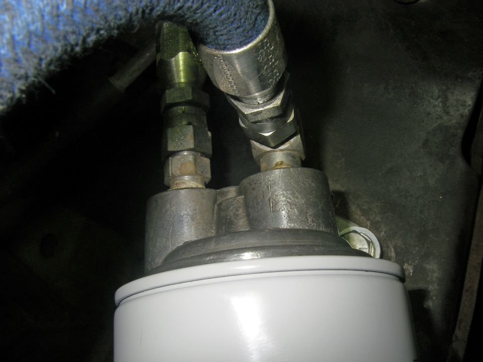 Oil filter assembly with two metal hoses connected to a silver metal base