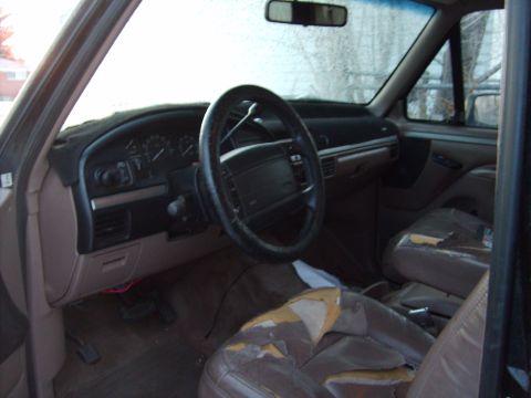 1995 Ford Bronco - The interior of a 1995 Ford Bronco features a worn dashboard and torn seats.