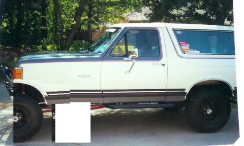 2006 Dodge 2500 - This lifted Ford Bronco features a two-tone paint scheme and aftermarket modifications, including a brush guard and side steps.
