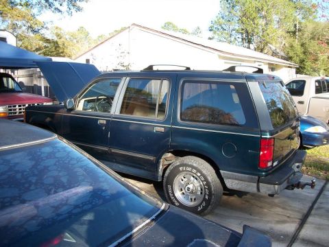 1994 Ford Explorer - Side view of a dark blue 1994 Ford Explorer SUV parked outdoors with its hood open.