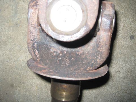 1979 Ford Bronco - A close-up view of a rusty driveshaft U-joint, a critical component for power transmission.