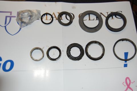 1994 Ford Bronco - A collection of automotive parts, including bearings and seals, are displayed on a white surface.