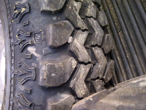 1990 Ford Bronco - A detailed view of the aggressive tread pattern on an off-road tire.