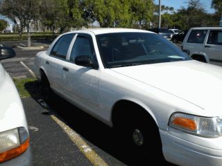 2002 Ford Crown Victoria - A white sedan is parked in a lot with another vehicle visible to the right.