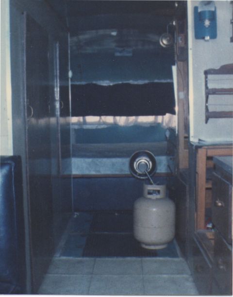 1968 Ford Mustang - The interior of a vehicle, possibly a camper or RV, is shown with a propane tank and curtains visible.