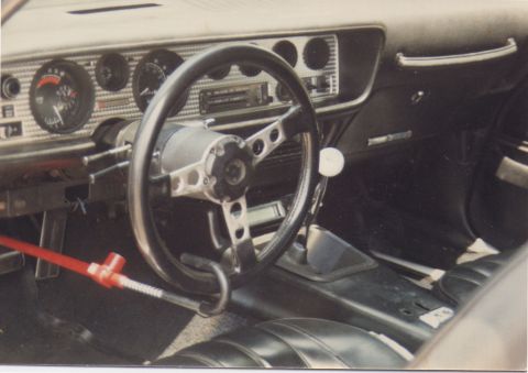 1968 Ford Mustang - The interior of a 1970 Pontiac Firebird shows an aftermarket steering wheel, shifter, and dashboard gauges.