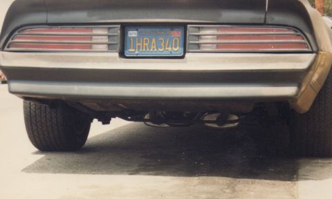 1968 Ford Mustang - 1977 Pontiac Firebird Trans Am rear view, showing California license plate 1HRA340 and dual exhaust.