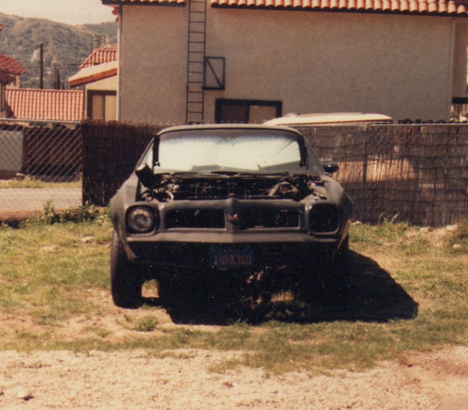 Front view of a dark car with hood open and license plate reading 'INR A340'