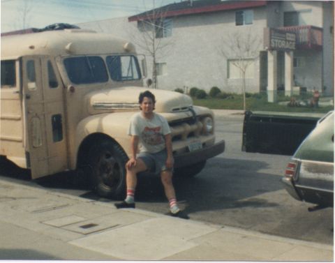 1968 Ford Mustang - Man poses next to a vintage school bus, with another vehicle visible on the right.