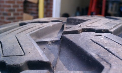 1990 Ford Bronco - A detailed view of a tire's tread pattern, showing its aggressive design and some accumulated debris.