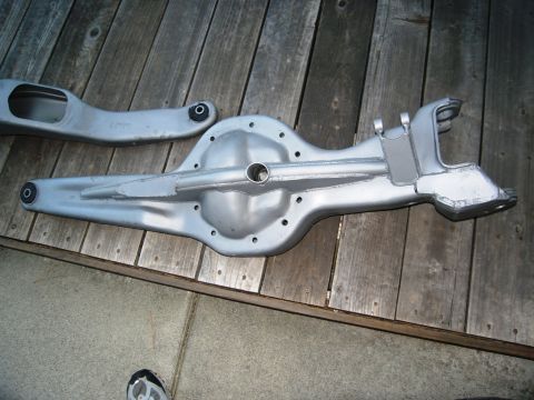 1986 Ford Bronco - Differential housing and suspension components are laid out on a wooden deck.