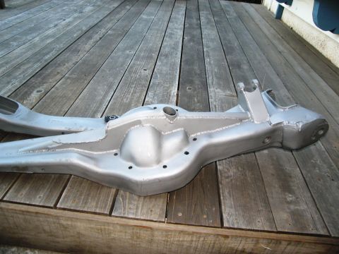 1986 Ford Bronco - Differential axle housing shown on a weathered wooden deck.